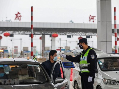 Kiểm tra thân nhiệt của lái xe trên tuyến đường cao tốc ở Vũ Hán, tỉnh Hồ Bắc, Trung Quốc, ngày 24/1. (Ảnh: AFP/TTXVN)
.