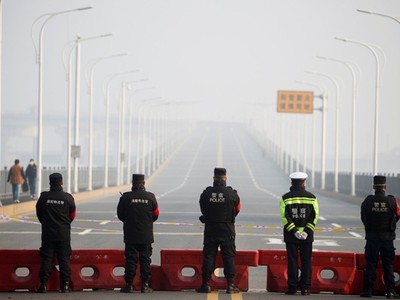 Cảnh sát được triển khai canh gác tại trạm kiểm soát trước cây cầu bắc qua sông Trường Giang nối Hồ Bắc với Cửu Giang. (Ảnh: Reuters).