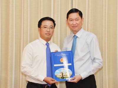 Ông Lê Huỳnh Minh Tú (trái) nhận quyết định bổ nhiệm giữ chức vụ Phó Giám đốc Sở Công thương TPHCM. Ảnh: Sài Gòn giải phóng online.