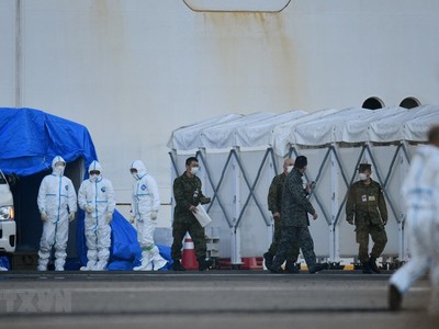 Nhân viên y tế làm nhiệm vụ gần du thuyền Diamond Princess bị cách ly tại cảng Yokohama, Nhật Bản ngày 13/2. (Ảnh: AFP/TTXVN).