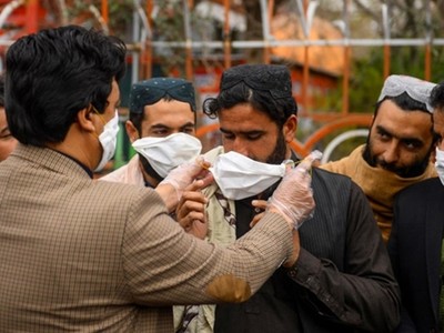 Tình nguyện viên Afghanistan phát khẩu trang tại Herat, nằm sát biên giới Iran ngày 26/2. Ảnh: AFP.