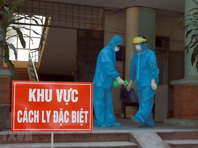 Các y bác sỹ Phòng khám Đa khoa khu vực Quang Hà mặc đồ bảo hộ và xịt nước xát khuẩn khi làm việc tại khu vực cách ly. (Ảnh: Hoàng Hùng/TTXVN).