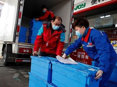 Công nhân trạm xăng của Sinopec tại Bắc Kinh bốc dỡ các thùng rau củ quả ngày 28/2. Đây là dịch vụ mới của Sinopec, gọi là đặt mua thực phẩm "không chạm" mùa dịch. Ảnh: Reuters.