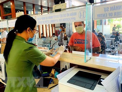 Cán bộ Công an cửa khẩu Tân Sơn Nhất chủ động trang bị đầy đủ khẩu trang, găng tay trong khi làm nhiệm vụ. (Ảnh: Thành Chung/TTXVN).