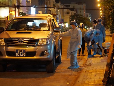 Nhân viên y tế chuẩn bị phun thuốc khử trùng khu vực nhà "bệnh nhân 34" ở TP Phan Thiết, tối 10/3.