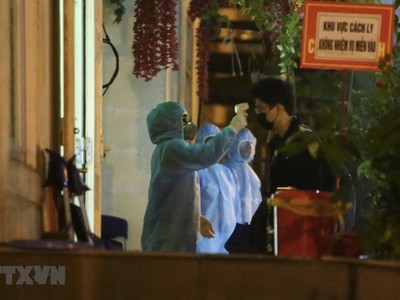 Nhân viên y tế sẽ đo thân nhiệt cho mỗi người trước khi vào khu cách ly. (Ảnh: Minh Quyết/TTXVN).