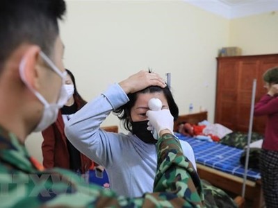 Kiểm tra thân nhiệt cho từng người mỗi sáng tại khu cách ly tập trung. (Ảnh: Thành Đạt/TTXVN).