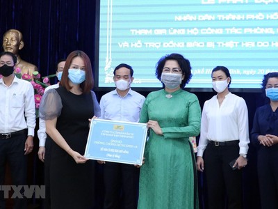Đại diện Tập đoàn Vạn Thịnh Phát (trái) trao tượng trưng số tiền ủng hộ cho Ủy ban Mặt trận Tổ quốc Việt Nam trong lễ phát động ủng hộ công tác phòng, chống dịch COVID-19 và ủng hộ đồng bào bị hạn hán, xâm nhập mặn. (Ảnh: TTXVN).