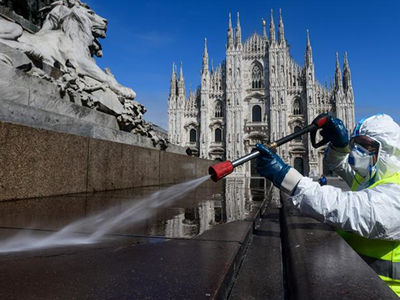 Nhân viên vệ sinh Italy phun khử trùng quảng trường Piazza ở Milan ngày 31/3. Ảnh: AFP.