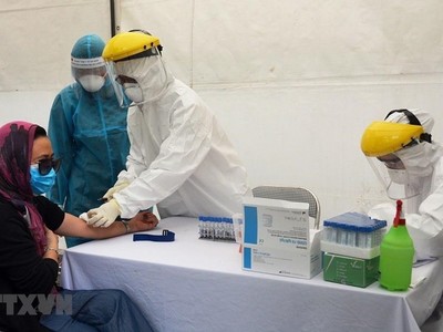 Lấy mẫu xét nghiệm virus SARS-CoV-2 cho người dân tại trạm xét nghiệm nhanh quận Ba Đình. (Ảnh: TTXVN phát).