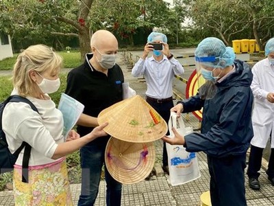 Lãnh đạo Sở Du lịch tỉnh Thừa Thiên-Huế tặng nón lá lưu niệm cho nữ bệnh nhân số 30. (Ảnh: Mai Trang/TTXVN).