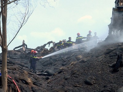 Cảnh sát liên tục đào bới, xịt nước ở kho hạt điều tránh bùng cháy trở lại.
