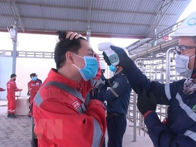 Tất cả các chuyên gia, lao động đều phải đo thân nhiệt cũng như rửa tay, sát khuẩn, khai báo y tế trước khi vào làm việc tại Khu kinh tế Nghi Sơn. (Ảnh: Khiếu Tư/TTXVN).