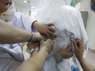 Các bác sĩ giúp đồng nghiệp dán kín đồ bảo hộ trước khi họ bước vào khu vực cách ly điều trị bệnh nhân, để đảm bảo chống lây nhiễm, Bệnh viện Bệnh Nhiệt đới Trung ương.