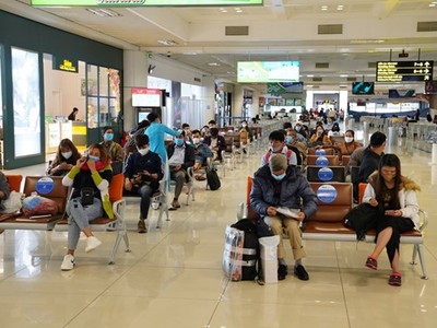 Hành khách tuân thủ giữ khoảng cách khi ngồi tại nhà ga tại sân bay Nội Bài. (Ảnh: Phan Công/Vietnam+).