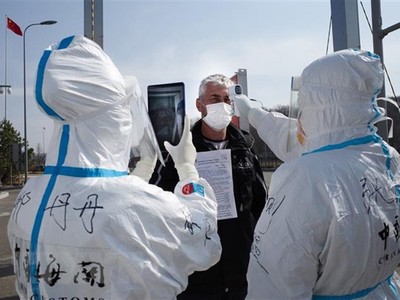 Nhân viên y tế Trung Quốc kiểm tra thân nhiệt ngăn chặn sự lây lan của dịch COVID-19 tại một trạm kiểm tra hải quan ở Suifenhe, tỉnh Hắc Long Giang, gần biên giới với Nga, ngày 1/5/2020. (Ảnh: AFP/TTXVN).