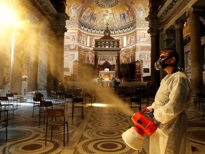 Người đàn ông khử trùng bên trong nhà thờ Santa Maria in Trastevere Basilica ở Rome, Italy, ngày 11/5. Ảnh: Reuters.
