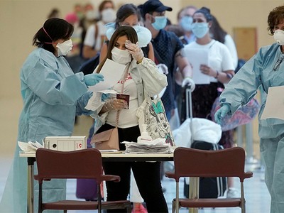 Hành khách đọc tài liệu do nhân viên y tế cung cấp khi tới sân bay Adolfo Suarez Barajas tại thủ đô Madrid, Tây Ban Nha, ngày 15/5. Ảnh: Reuters.