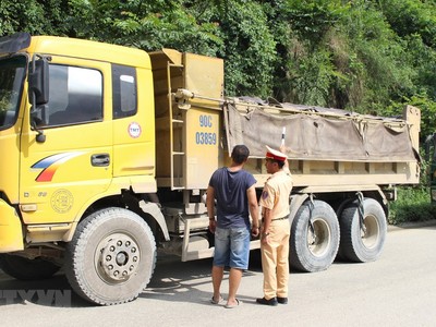 Cảnh sát giao thông kiểm tra một xe tải lưu thông trên đường. Ảnh minh họa. (Nguồn: TTXVN).