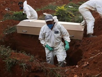 Những phu đào mộ mặc đồ bảo hộ chuẩn bị chôn cất quan tài một nạn nhân Covid-19 trong tang lễ không có người thân ở Sao Paolo, Brazil hôm 22/5. Ảnh: AFP.