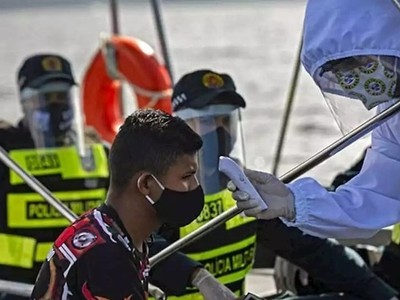 Nhân viên y tế chính phủ Brazil phối hợp cùng cảnh sát kiểm tra thân nhiệt cho một khách đi tàu ở bang Para hôm 27/5. Ảnh: AFP.