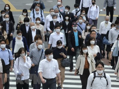 Người dân đeo khẩu trang phòng dịch COVID-19 khi di chuyển trên phố ở Tokyo, Nhật Bản ngày 26/5/2020. (Nguồn: AFP/TTXVN).