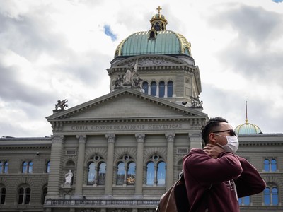 Du khách đeo khẩu trang đi ngang qua Tòa nhà Quốc hội Thụy Sĩ. (Nguồn: AFP).