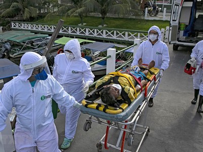 Nhân viên y tế chuyển bệnh nhân mắc COVID-19 tới một bệnh viện ở bang Para, Brazil. (Ảnh: AFP/TTXVN).