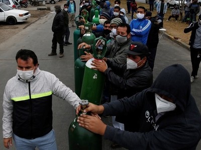 Người dân đeo khẩu trang xếp hàng chờ bên ngoài một cửa hàng phân phối oxy ở thủ đô Lima, Peru hôm 25/6. Ảnh: Reuters.