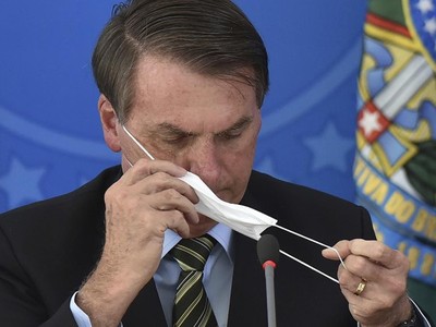 Tổng thống Jair Bolsonaro tháo khẩu trang trong cuộc họp báo. Ảnh: AP.