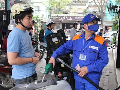 Nhân viên Petrolimex đang bán xăng cho khách hàng. (Ảnh: Đức Duy/Vietnam+).