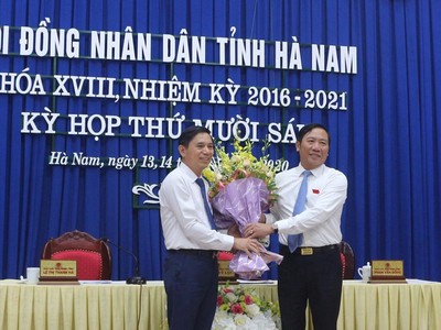 Ông Phạm Sỹ Lợi, Phó Bí thư thường trực Tỉnh ủy, Chủ tịch HĐND tỉnh Hà Nam tặng hoa chúc mừng ông Trần Xuân Dưỡng.