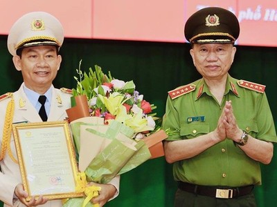 Đại tướng Tô Lâm thừa uỷ quyền của Chủ tịch nước trao quyết định và tặng hoa chúc mừng Thiếu tướng Đinh Thanh Nhàn.