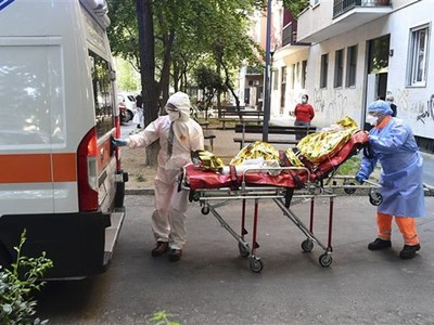 Nhân viên y tế chuyển bệnh nhân COVID-19 tới bệnh viện tại Milan, Italy. (Ảnh: AFP/TTXVN).