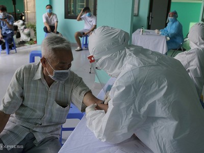 Nhân viên y tế phường Yên Hòa, quận Cầu Giấy lấy mẫu máu xét nghiệm cho người về từ Đà Nẵng ngày 30/7.