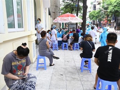 Người về từ Đà Nẵng chờ xét nghiệm nhanh tại phường Bách Khoa và phường Cầu Dền (quận Hai Bà Trưng,Hà Nội) sáng 1/8. (Ảnh: Minh Quyết/TTXVN).