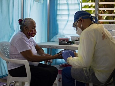 Y tá lấy mẫu máu của người phụ nữ tại El Salvador ngày 30/7. Ảnh: AFP.