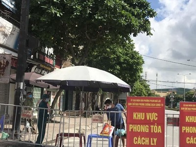 Người dân trong khu vực phong tỏa trên phố Ngô Quyền (Hải Dương) nhận thực phẩm tiếp tế tại hàng rào cách ly ngày 16/8. (Ảnh: Mạnh Minh/TTXVN)
.