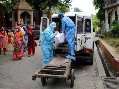 Các nhân viên y tế di chuyển thi thể một người chết vì nCoV tại New Delhi, Ấn Độ, hôm 22/8. Ảnh: Reuters.