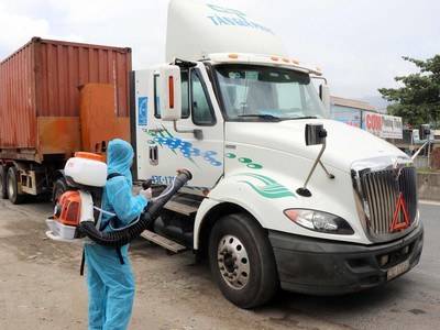 Nhân viên y tế phun thuốc khử khuẩn đối với những xe chở hàng hóa đến từ vùng dịch bệnh tại chốt kiểm soát dịch bệnh số 6 của Thừa Thiên-Huế. (Ảnh: Đỗ Trưởng/TTXVN).