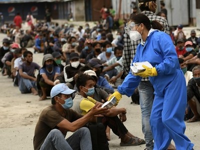 Tình nguyện viên phát thức ăn cho người dân tại khu vực bị áp hạn chế ngăn Covid-19 ở Kathmandu, Nepal hôm 31/8. Ảnh: AFP.