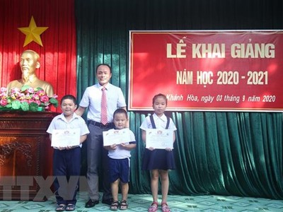 Đại biểu cùng học sinh và giáo viên Trường Tiểu học thị trấn Trường Sa chụp ảnh lưu niệm trong ngày khai giảng. (Ảnh: TTXVN)