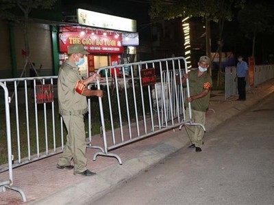 Lực lượng chức năng tiến hành tháo dỡ rào chắn phong tỏa tại một tuyến phố. (Ảnh: Mạnh Minh/TTXVN).