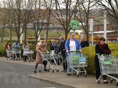 Người dân xếp hàng chờ mua sắm bên ngoài một siêu thị ở Gateshead, Anh. (Ảnh: AFP/TTXVN).