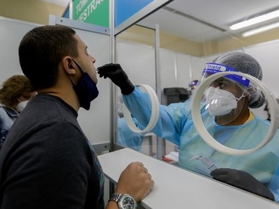 Nhân viên y tế lấy mẫu xét nghiệm Covid-19 cho một người đàn ông ở Sân bay Quốc tế Tocumen, Panama City, thủ đô của Panama hôm 12/10. Ảnh: AFP.