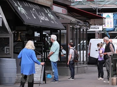 Người dân xếp hàng bên ngoài một hiệu bánh ở Paris, Pháp. (Ảnh: THX/TTXVN).