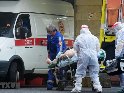 Nhân viên y tế chuyển bệnh nhân mắc COVID-19 lên xe cứu thương tại Saint Petersburg, Nga ngày 5/10/2020. (Ảnh: AFP/TTXVN).
