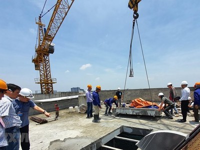 Đơn vị tháo dỡ cắt xong một ô sàn tầng 18 tòa nhà 8B Lê Trực. (Ảnh Mạnh Khánh/TTXVN).