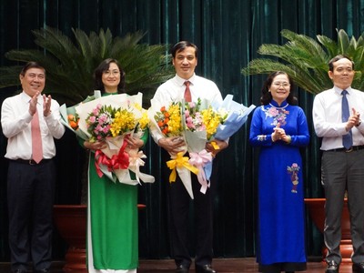 Ông Lê Hoà Bình và bà Phan Thị Thắng nhận hoa chúc mừng từ lãnh đạo TPHCM.