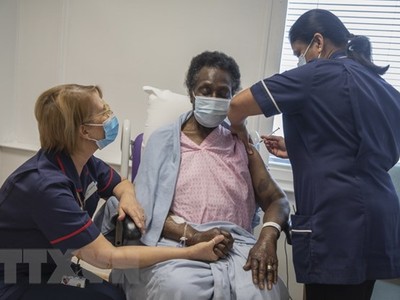 Nhân viên y tế tiêm vắcxin phòng COVID-19 của Pfizer-BioNTech cho người dân tại London, Anh, ngày 8/12. (Ảnh: AFP/TTXVN).